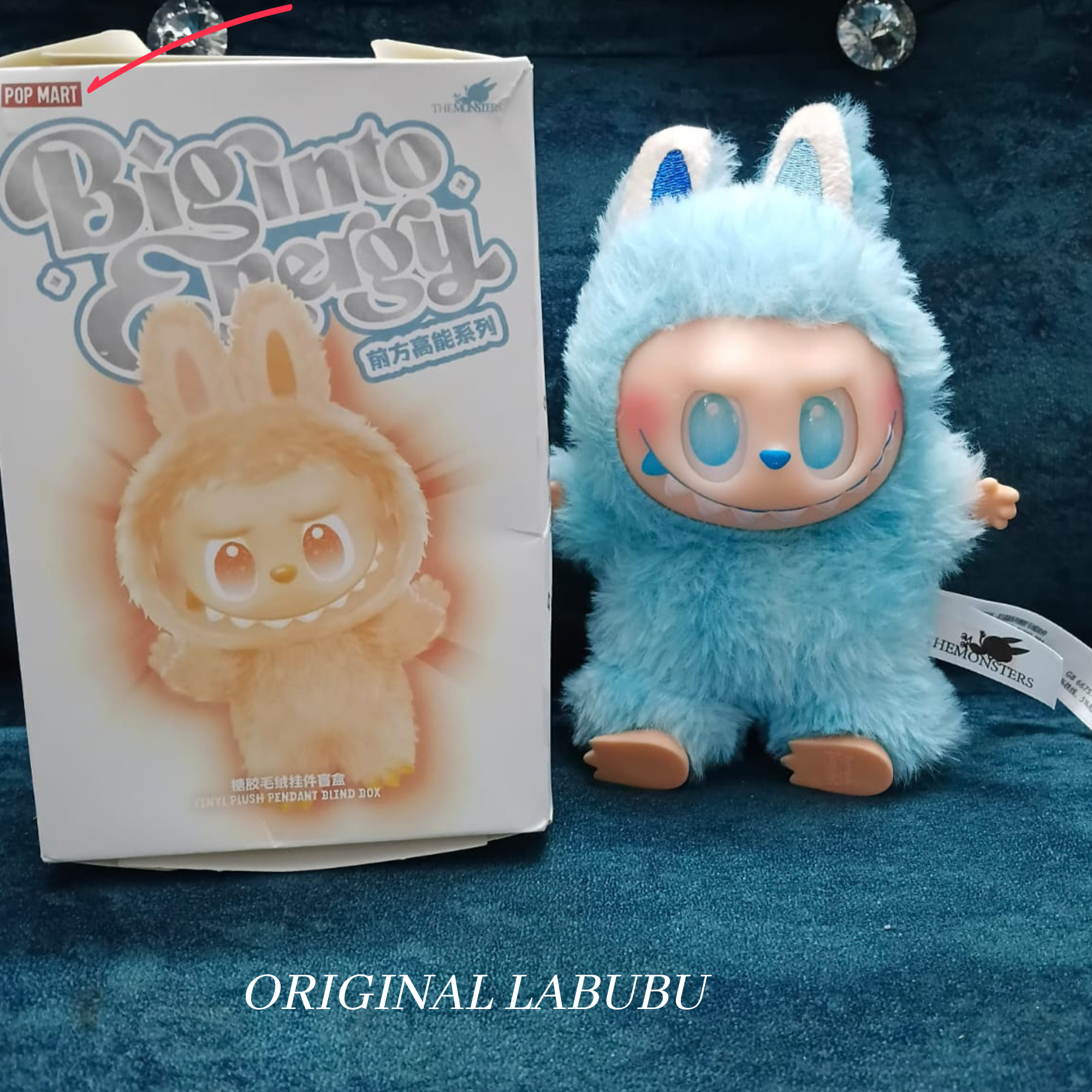 Blue plush toy resembling a bunny with packaging labeled 'Big into Pop Mart Labubu' on a dark blue background.