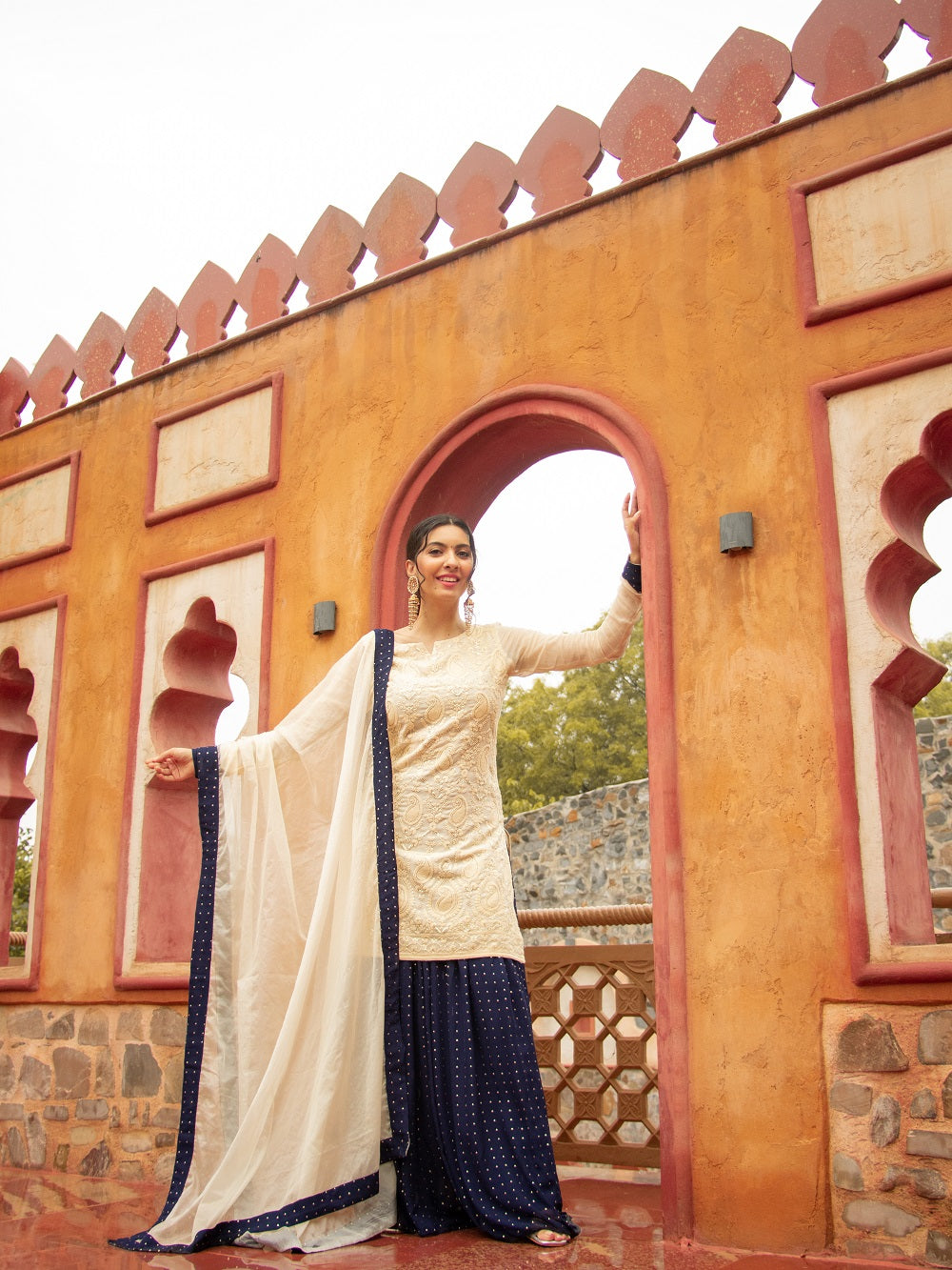 Be elegant and glamorous in this 3-piece formal set, crafted with exquisite chikankari and viscose georgette fabric with a traditional kajol inspired style. Lined with crepe fabric all over, this ivory Indo-Western look by Saadgi. chicken, chikan kurti, chikan suit, chikankari kurta for women, chikankari kurta, chikankari kurta set, chikankari short kurti, chikankari suit set, gharara, chikankari suits, hand crafted, lakhnavi kurti, lucknowi chikankari kurti, lucknowi kurti, lucknowi
