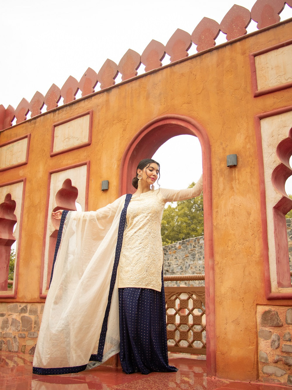 Be elegant and glamorous in this 3-piece formal set, crafted with exquisite chikankari and viscose georgette fabric with a traditional kajol inspired style. Lined with crepe fabric all over, this ivory Indo-Western look by Saadgi. chicken, chikan kurti, chikan suit, chikankari kurta for women, chikankari kurta, chikankari kurta set, chikankari short kurti, chikankari suit set, gharara, chikankari suits, hand crafted, lakhnavi kurti, lucknowi chikankari kurti, lucknowi kurti, lucknowi