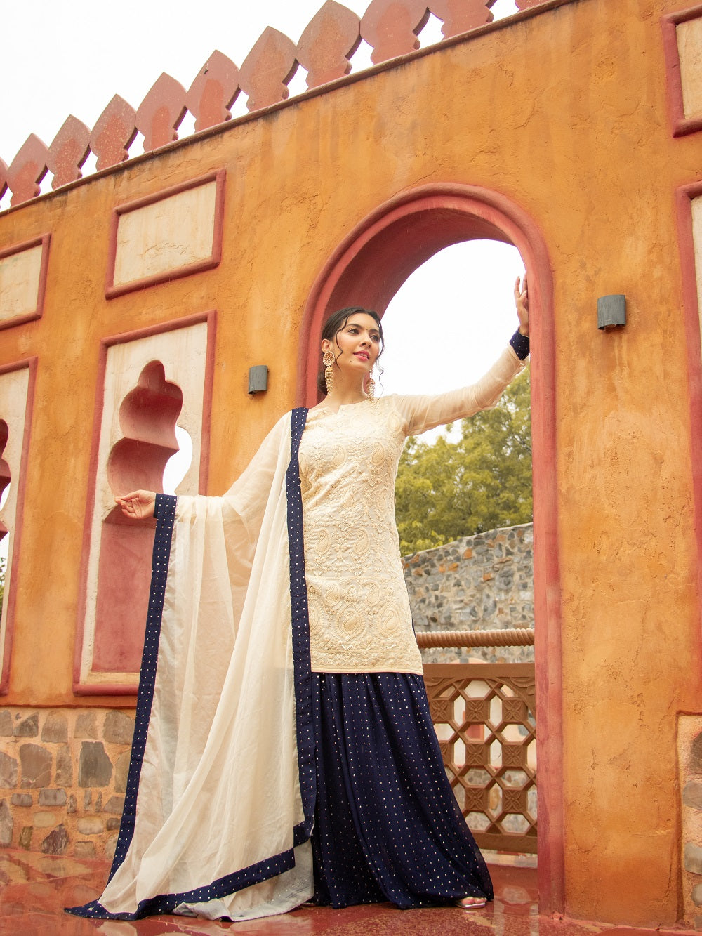 Be elegant and glamorous in this 3-piece formal set, crafted with exquisite chikankari and viscose georgette fabric with a traditional kajol inspired style. Lined with crepe fabric all over, this ivory Indo-Western look by Saadgi. chicken, chikan kurti, chikan suit, chikankari kurta for women, chikankari kurta, chikankari kurta set, chikankari short kurti, chikankari suit set, gharara, chikankari suits, hand crafted, lakhnavi kurti, lucknowi chikankari kurti, lucknowi kurti, lucknowi
